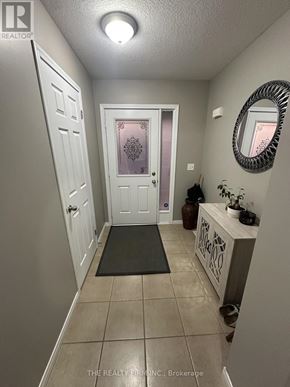 London East (East D) townhouse for rent - A hallway with a door, a mirror, and a plant.