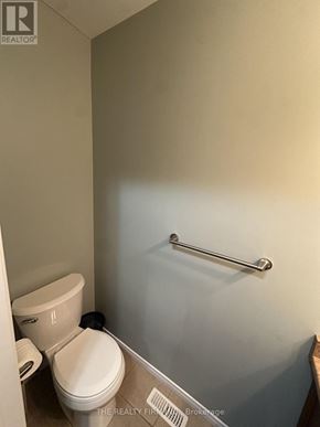 London East (East D) townhouse for rent - A white toilet with a toilet paper roll on the side.