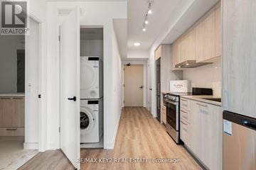 Vaughan (Vaughan Corporate Centre) condo for rent - A modern kitchen with wooden cabinets and stainless steel appliances.