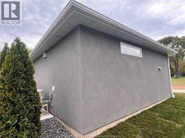 Harrow apartment for rent - A grey building with a small window and a sign that says REALTOR.