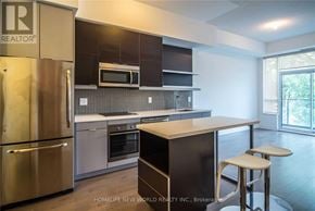 Toronto (Willowdale East) condo for rent - A modern kitchen with stainless steel appliances and a breakfast bar.