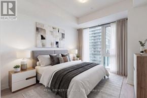 Vaughan (Vellore Village) condo for rent - A bedroom with a large bed, a nightstand with a lamp, and a painting on the wall.