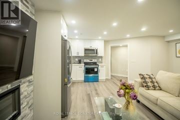 Georgina (Keswick North) apartment for rent - A modern kitchen with a glass table and a couch in the living room.