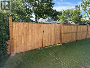 St. Thomas apartment for rent - A wooden fence in a yard with a house and trees in the background.