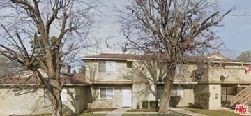 Bakersfield apartment for rent - A large house with a tree in front of it.