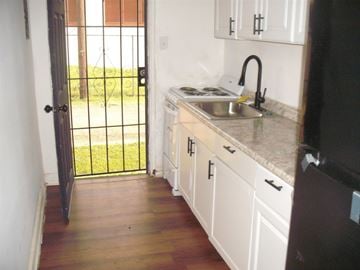 Birmingham apartment for rent - A kitchen with white cabinets and a black fridge.