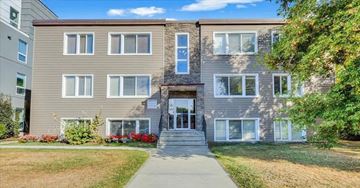 Edmonton apartment for rent - A modern two-story building with a front porch and a well-maintained lawn.