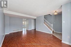 London East (East I) townhouse for rent - A spacious room with wooden floors and a staircase.