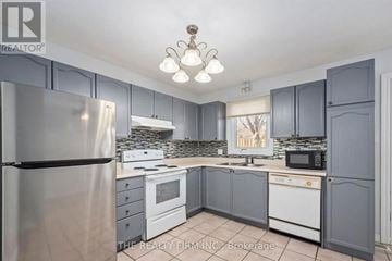 London East (East I) townhouse for rent - A kitchen with a refrigerator, microwave, oven, and sink.