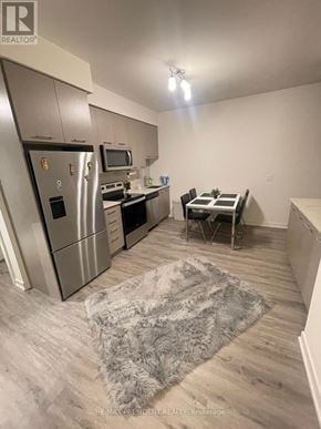 Grimsby (Grimsby Beach) condo for rent - A modern kitchen with a refrigerator, oven, microwave, and dining table.