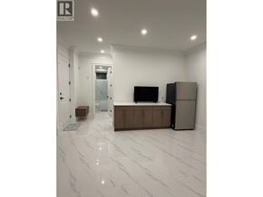 North Vancouver apartment for rent - A white tiled room with a cabinet and a television.