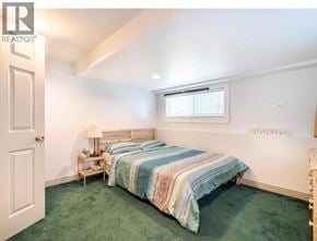 North Vancouver apartment for rent - A bedroom with a bed, nightstand, and window.