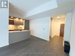 Toronto (Church-Yonge Corridor) townhouse for rent - A spacious room with a kitchen area and a door leading to another room.