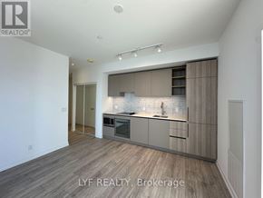 Toronto (Waterfront Communities) condo for rent - A modern kitchen with wooden flooring and a white ceiling.