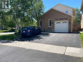 Pickering (Amberlea) apartment for rent - A blue car is parked in front of a brick house with a garage.