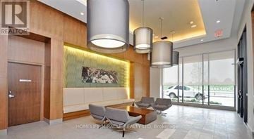 Mississauga (Creditview) condo for rent - A modern living room with a large painting on the wall and a view of a parking lot outside.