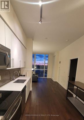 Mississauga (Creditview) condo for rent - A modern kitchen with dark wood floors and white cabinetry.