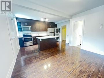 Toronto (Dovercourt-Wallace Emerson-Junction) apartment for rent - A spacious kitchen with dark wood floors and modern appliances.
