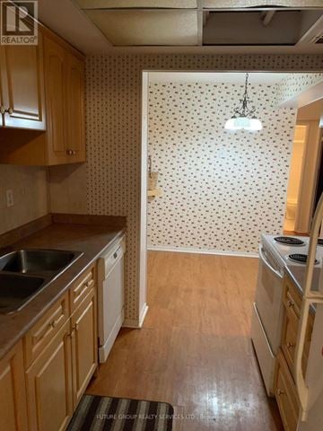 Mississauga (Cooksville) condo for rent - A kitchen with wooden cabinets and a white fridge.