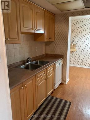 Mississauga (Cooksville) condo for rent - A kitchen with wooden cabinets and a sink.