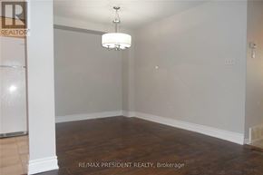 Kitchener townhouse for rent - A room with a wooden floor and a chandelier hanging from the ceiling.