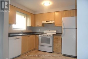 Kitchener townhouse for rent - A kitchen with wooden cabinets and white appliances.