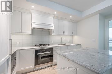 Ottawa condo for rent - A kitchen with white cabinets and a marble countertop.