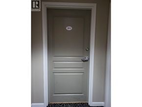 Burnaby apartment for rent - A white door with a silver handle and a number 311 on the door.