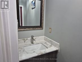 Vaughan (Maple) townhouse for rent - A bathroom sink with a marble pattern top and a mirror above it.