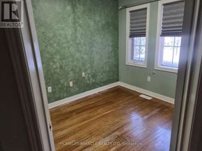 Vaughan (Maple) townhouse for rent - A room with wooden floors and green wallpapered walls.