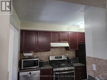 Vaughan (Maple) townhouse for rent - A kitchen with brown cabinets and a black stove top oven.