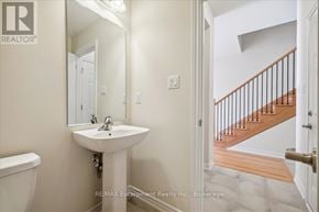 Burlington (Tyandaga) townhouse for rent - A white bathroom with a sink, mirror, and toilet.