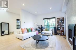 Toronto (Mount Pleasant East) apartment for rent - A living room with a white couch, a black coffee table, and a bookshelf.