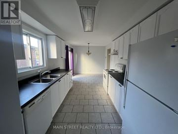 Georgina (Keswick North) apartment for rent - A kitchen with white cabinets and black countertops.