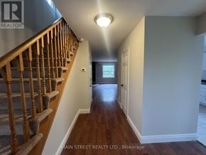 Georgina (Keswick North) apartment for rent - A hallway with a staircase on the left and a door on the right.