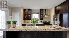 Mississauga (Lakeview) apartment for rent - A kitchen with a marble countertop and dark wood cabinets.