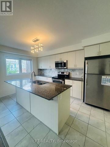 Kitchener townhouse for rent - A kitchen with a granite countertop and stainless steel appliances.