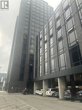 Waterloo condo for rent - A tall building with a parking lot in front of it.