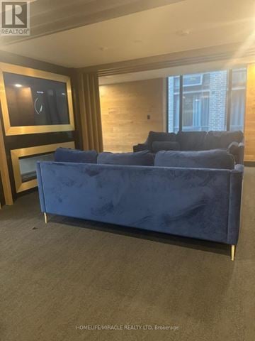 Waterloo condo for rent - A blue couch in a living room with a tv on the wall.