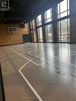 Waterloo condo for rent - A basketball court inside a gym with a wooden wall and a basketball hoop.