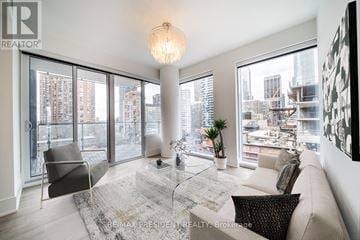 Toronto (Church-Yonge Corridor) condo for rent - A living room with a couch, chair, and a table with a plant on it.