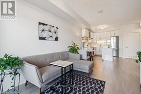Burlington (Freeman) condo for rent - A living room with a grey sofa, a small table, and a framed picture on the wall.