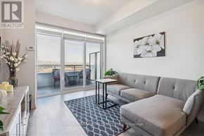 Burlington (Freeman) condo for rent - A living room with a grey sofa and a table with a vase of flowers on it.