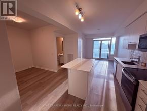 Grimsby (Grimsby Beach) condo for rent - A well-lit kitchen and living room with wooden floors and white walls.