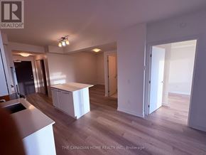 Grimsby (Grimsby Beach) condo for rent - A realtor photo of a white kitchen with wood floors and a white island.