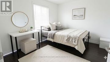 London North (North N) apartment for rent - A bedroom with a bed, a table, and a round mirror on the wall.