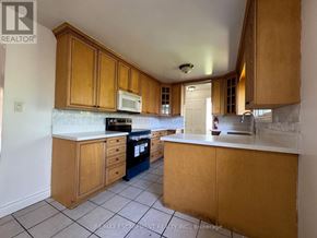 Hamilton (Balfour) apartment for rent - A kitchen with wooden cabinets and a white countertop.