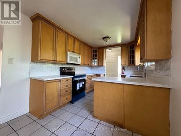 Hamilton (Balfour) apartment for rent - A kitchen with wooden cabinets and a white countertop.