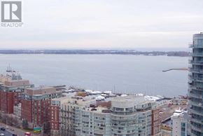 Toronto (Waterfront Communities) condo for rent - A cityscape with buildings and a body of water in the background.