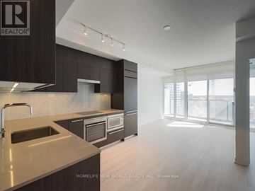 Toronto (Waterfront Communities) condo for rent - A modern kitchen with dark brown cabinets and a marble countertop.